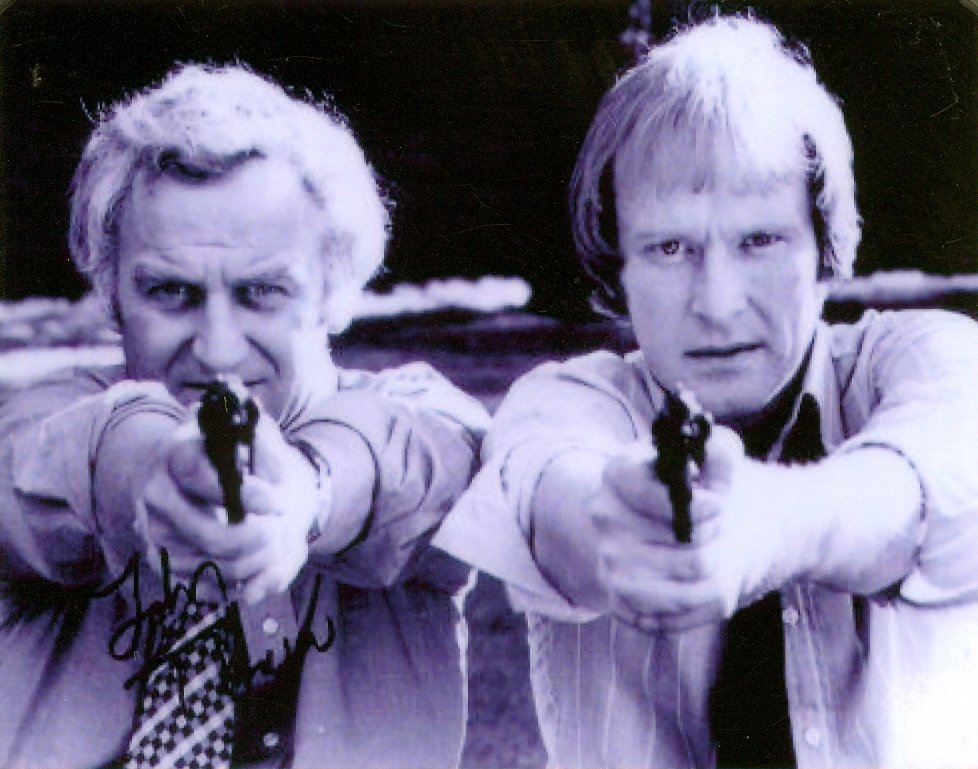 two men holding guns looking at the camera