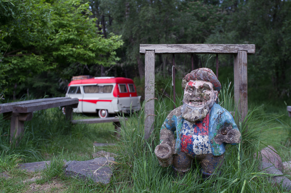 the statue sits near the fence and has a van behind it