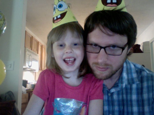 a man and a little girl wearing party hats