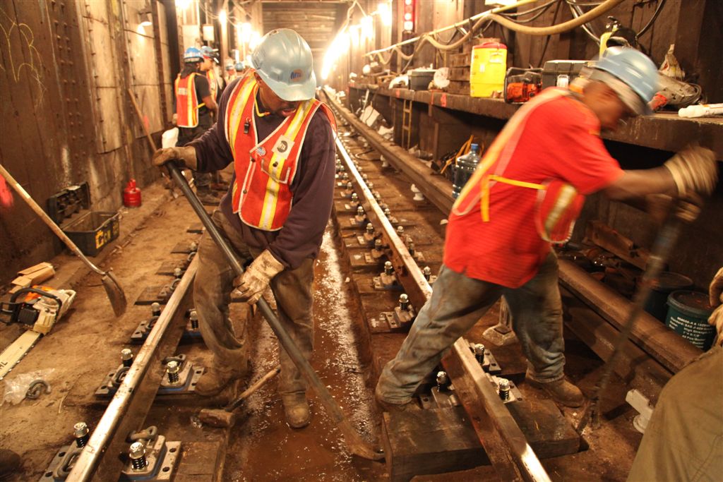 there are two men that are working on the tracks