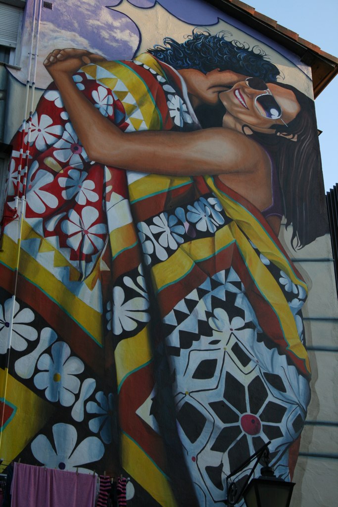 a painting on the side of a building of a woman