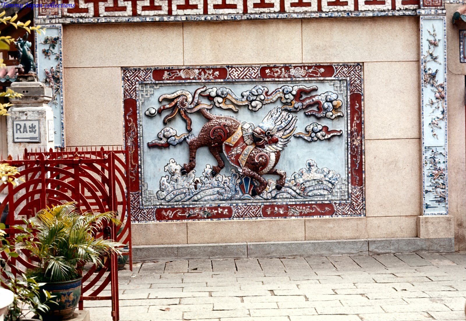 a wall covered in artwork sitting under a building