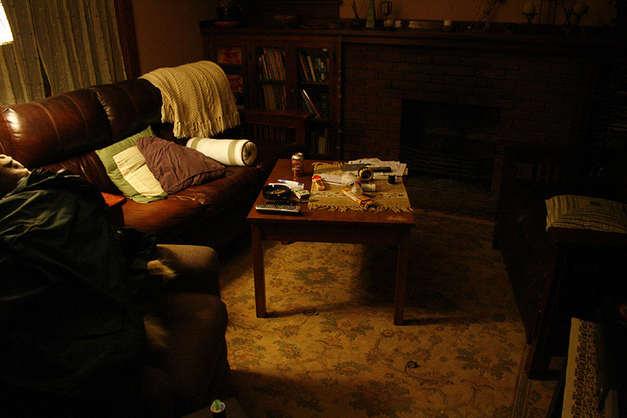 a man sitting in a living room next to a dog