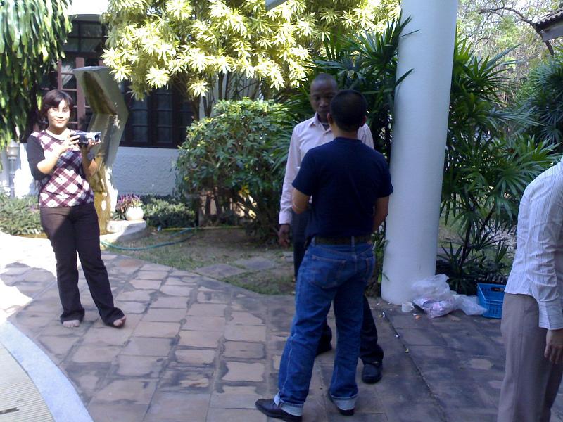 the people are gathered in front of a large house