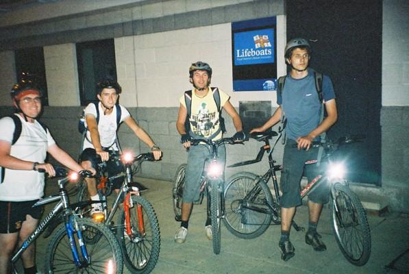 some people that are standing with bikes in front of the building