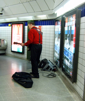a man standing in a subway station next to a large subway door