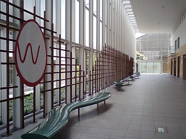 an empty hallway with long benches next to it