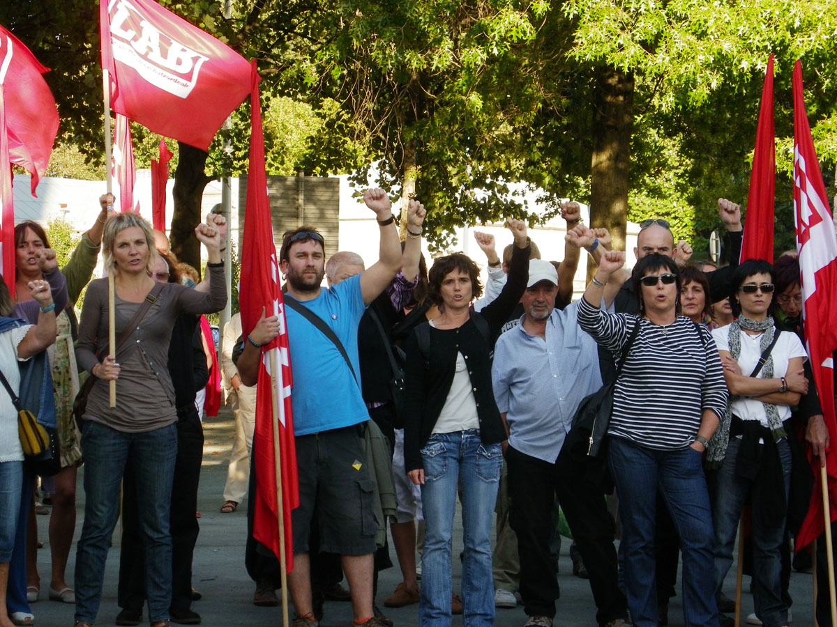 many people are holding red and white flags in front of some trees