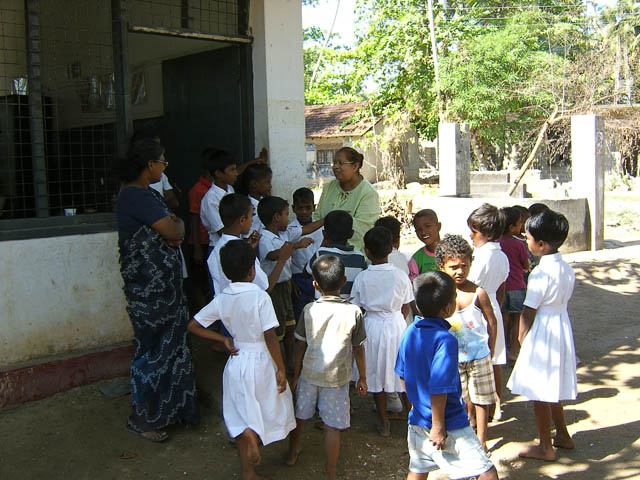 a man in white is talking to children