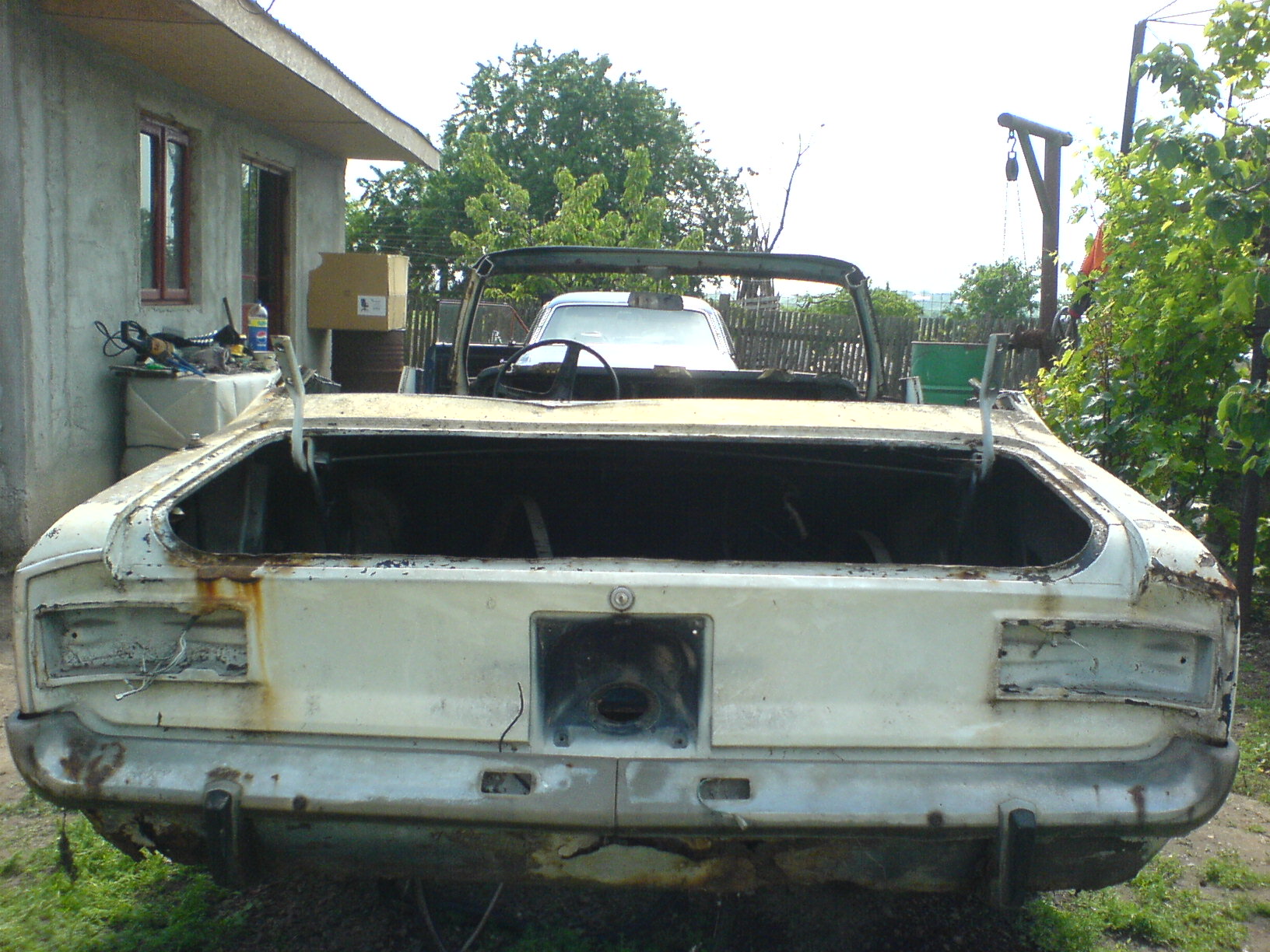 an old car that is outside in the dirt