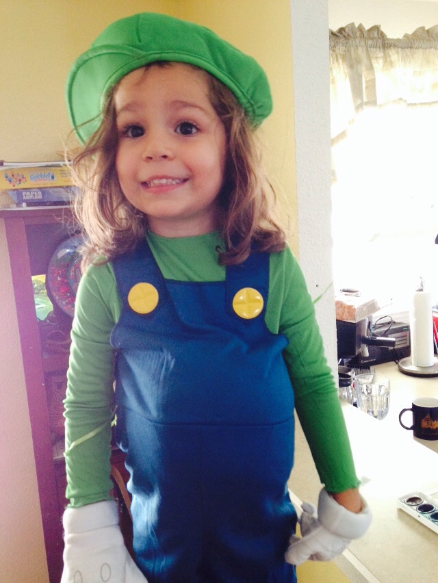 the little girl is dressed up as a luigi