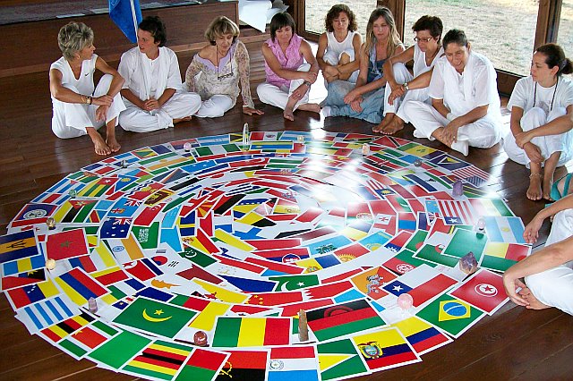 people are sitting on the floor, with a circular array of flags