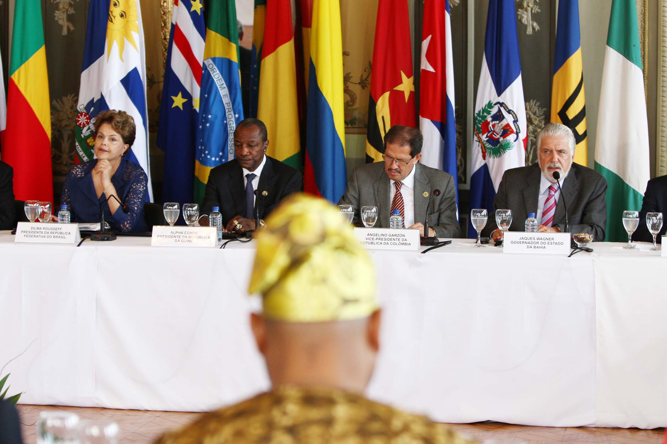 people sit at a table with flags behind them