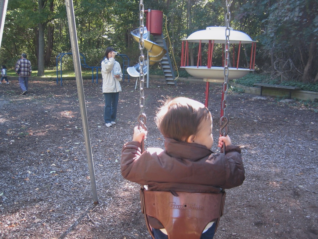 a child is looking at two people in the playground