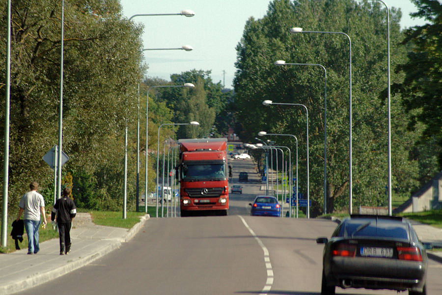 two red double decker buses driving down a street