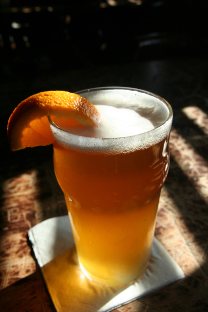 a beverage with an orange garnish on top