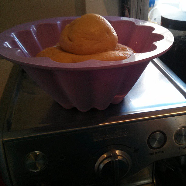 a bowl of orange icing with one in the background