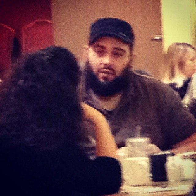 a man with a beard sitting at a table with two women