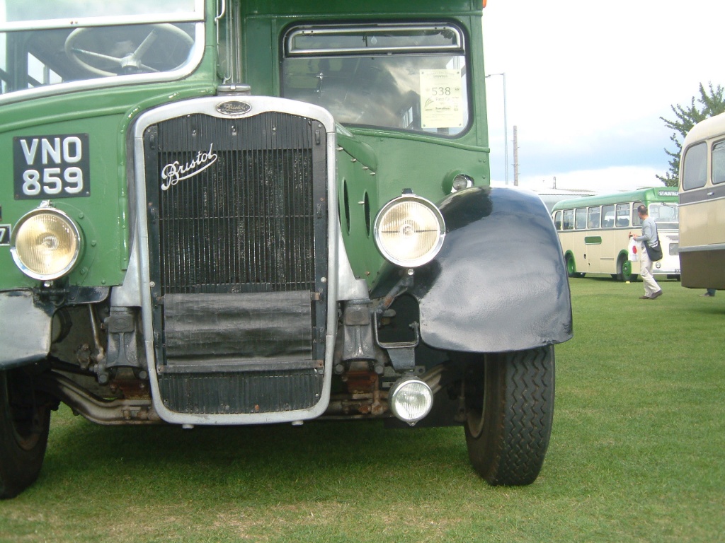 an old vintage green truck parked on top of a grass covered field