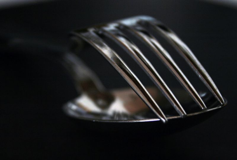 a small silver fork on a black surface