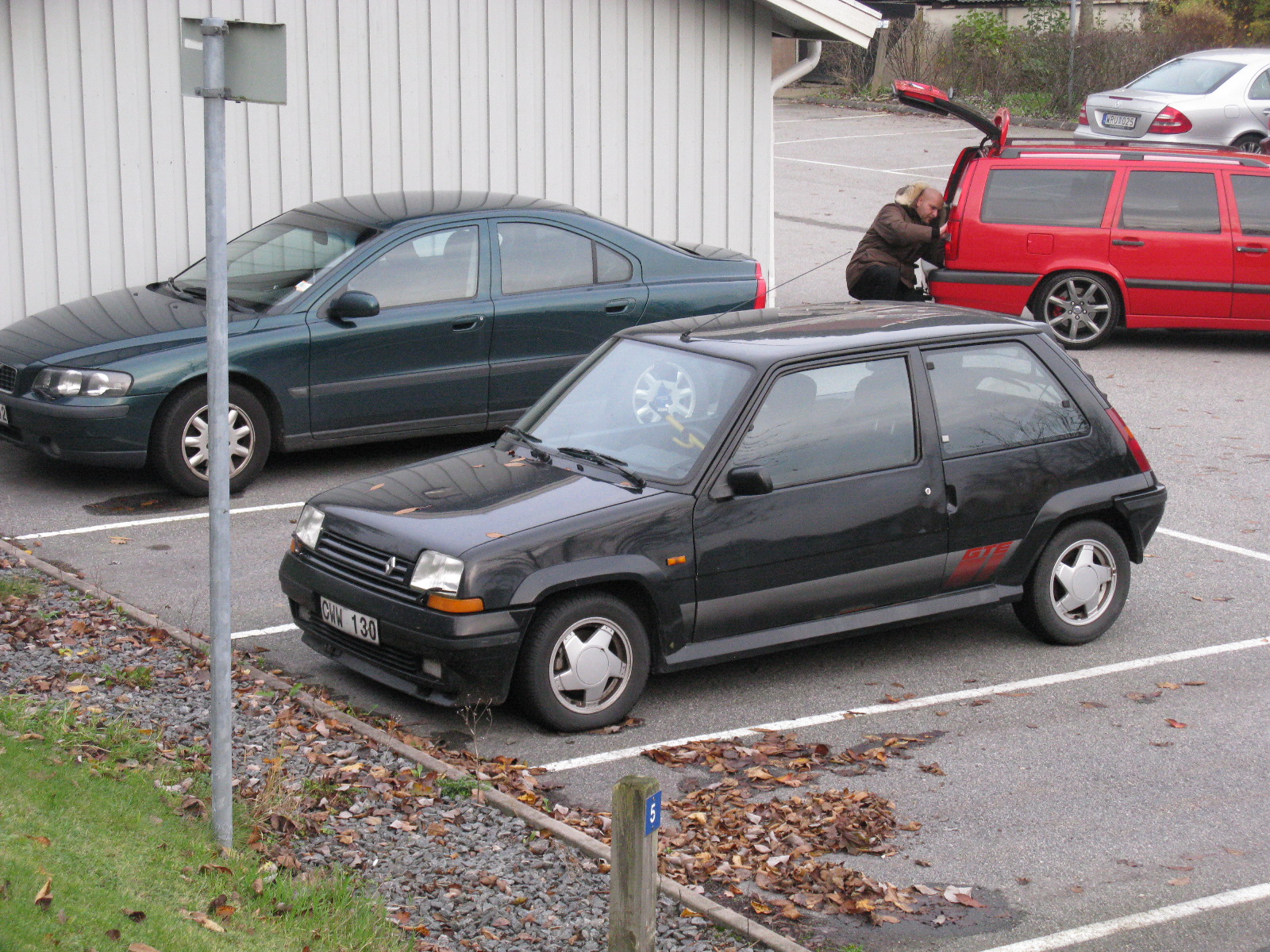 two cars are parked in an open parking lot