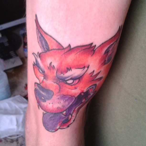 a tattoo on the leg of a person with a red and purple tattoo on it