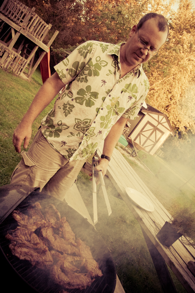 the man is preparing some food outside in the backyard