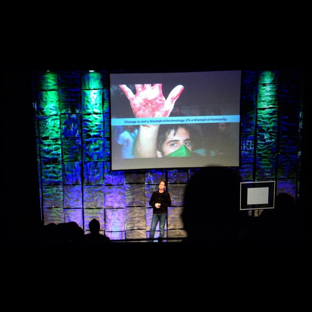 a stage with a woman giving a presentation on the screen