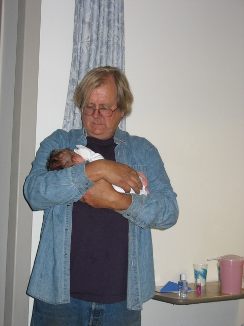 the man has his arms wrapped around a newborn