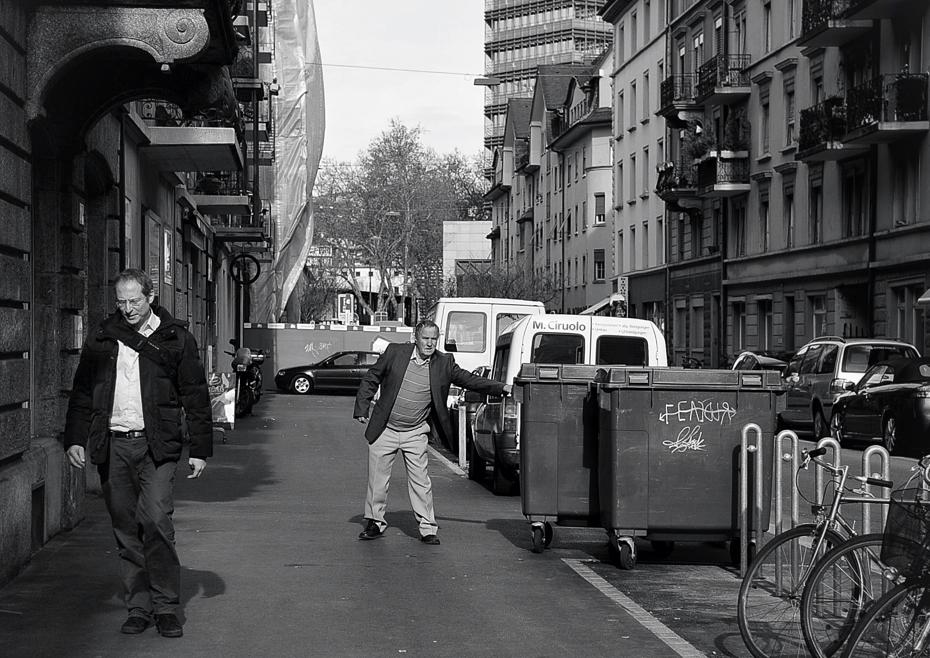 a man walking down the road while another skates