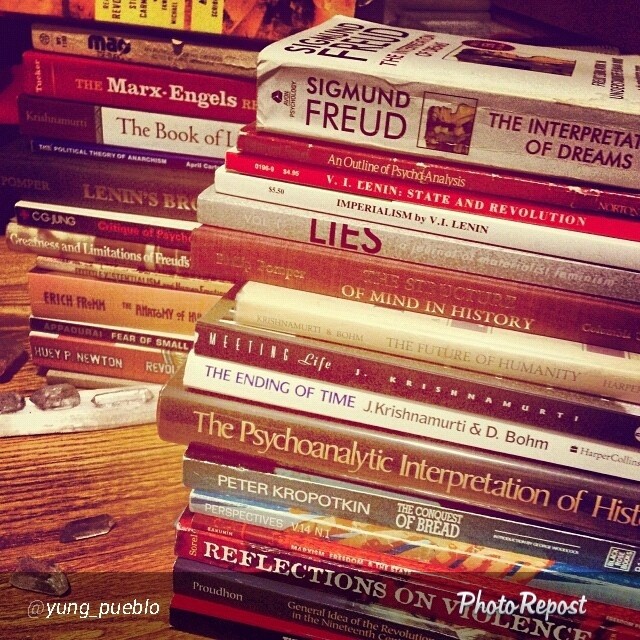 stack of books in the corner of a wooden table