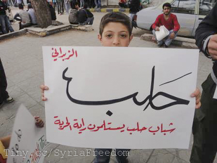 a boy holding up a poster with arabic writing