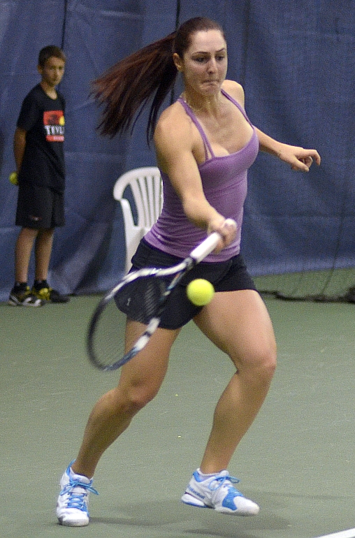 a female tennis player about to hit the ball with her racket