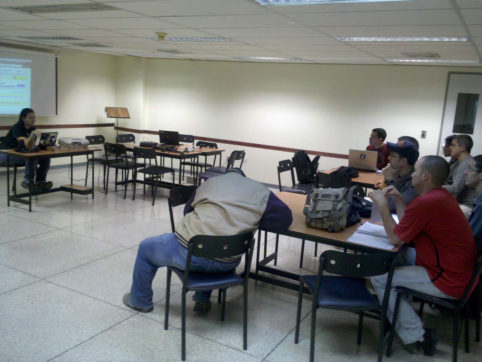 there is an class room with people sitting at the tables