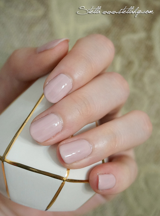 hand holding up a white and gold manicure on its tip