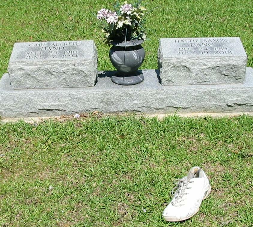 there is a shoe and a vase sitting on the gravestones