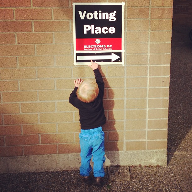 a  putting his hands in the voting place sign