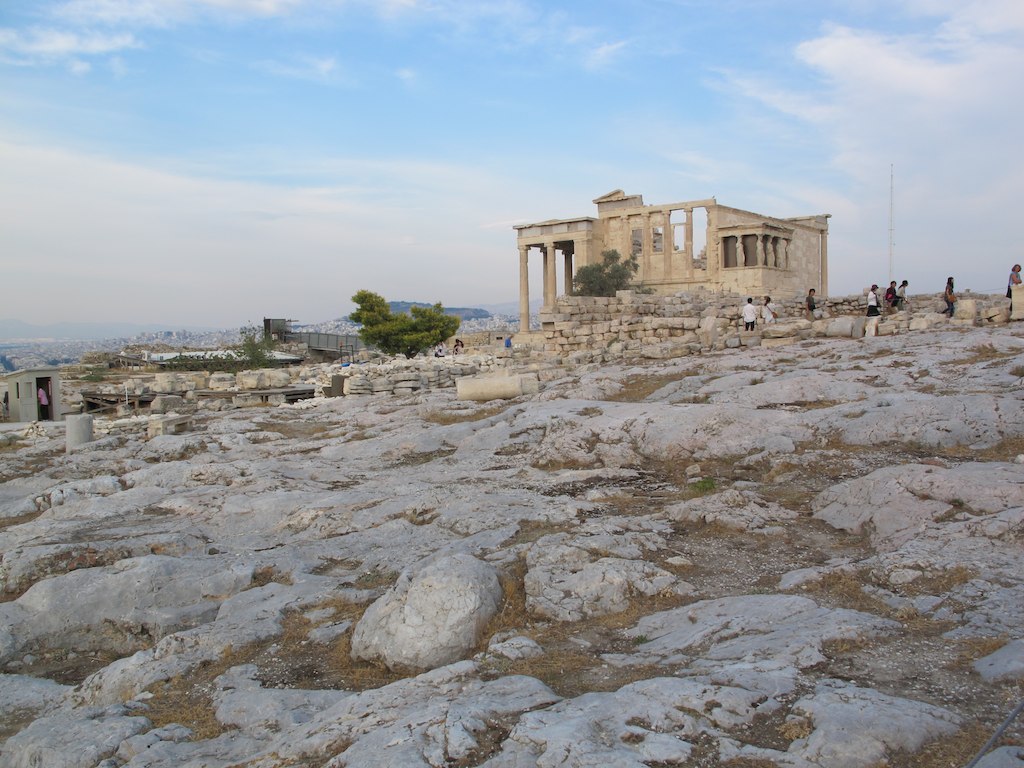 several people standing on a rocky area near a building