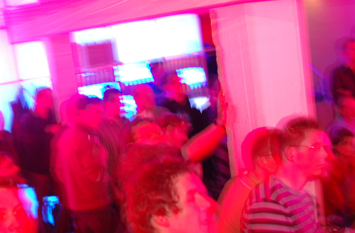 people are dancing around in a room with a pink glow