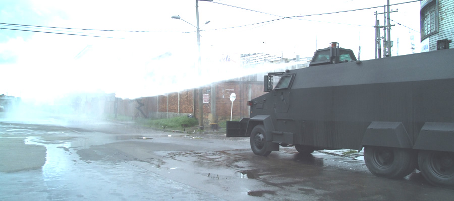 an armored vehicle with fog and water on the road