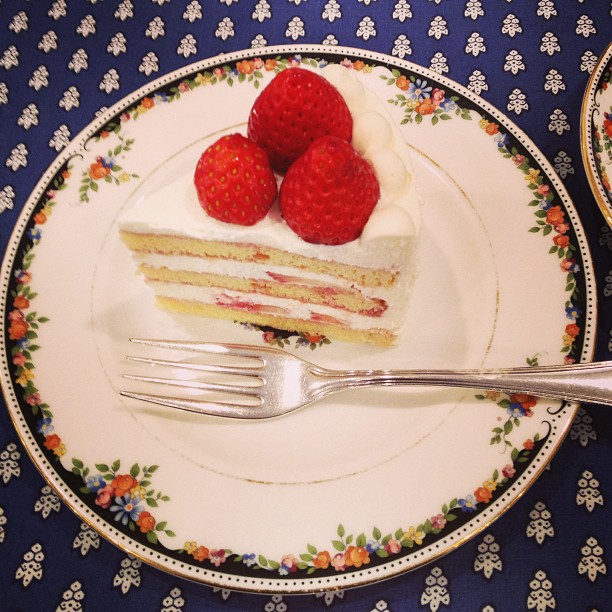 three slices of cake are served on floral - plated serving dishes