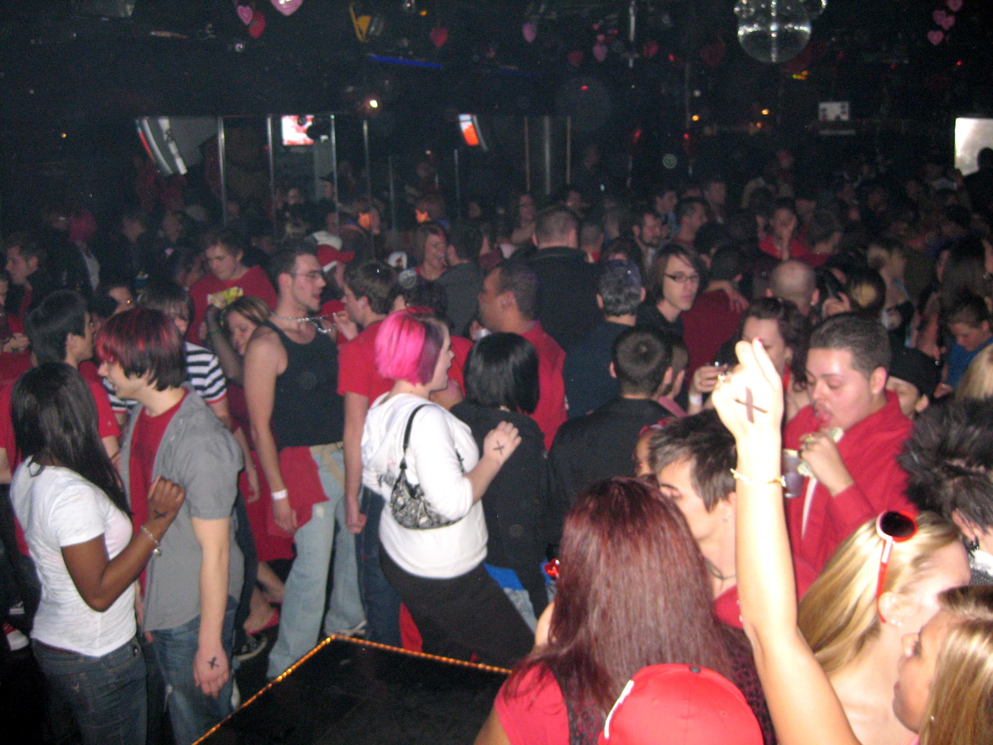 many people standing in a crowded area at a nightclub