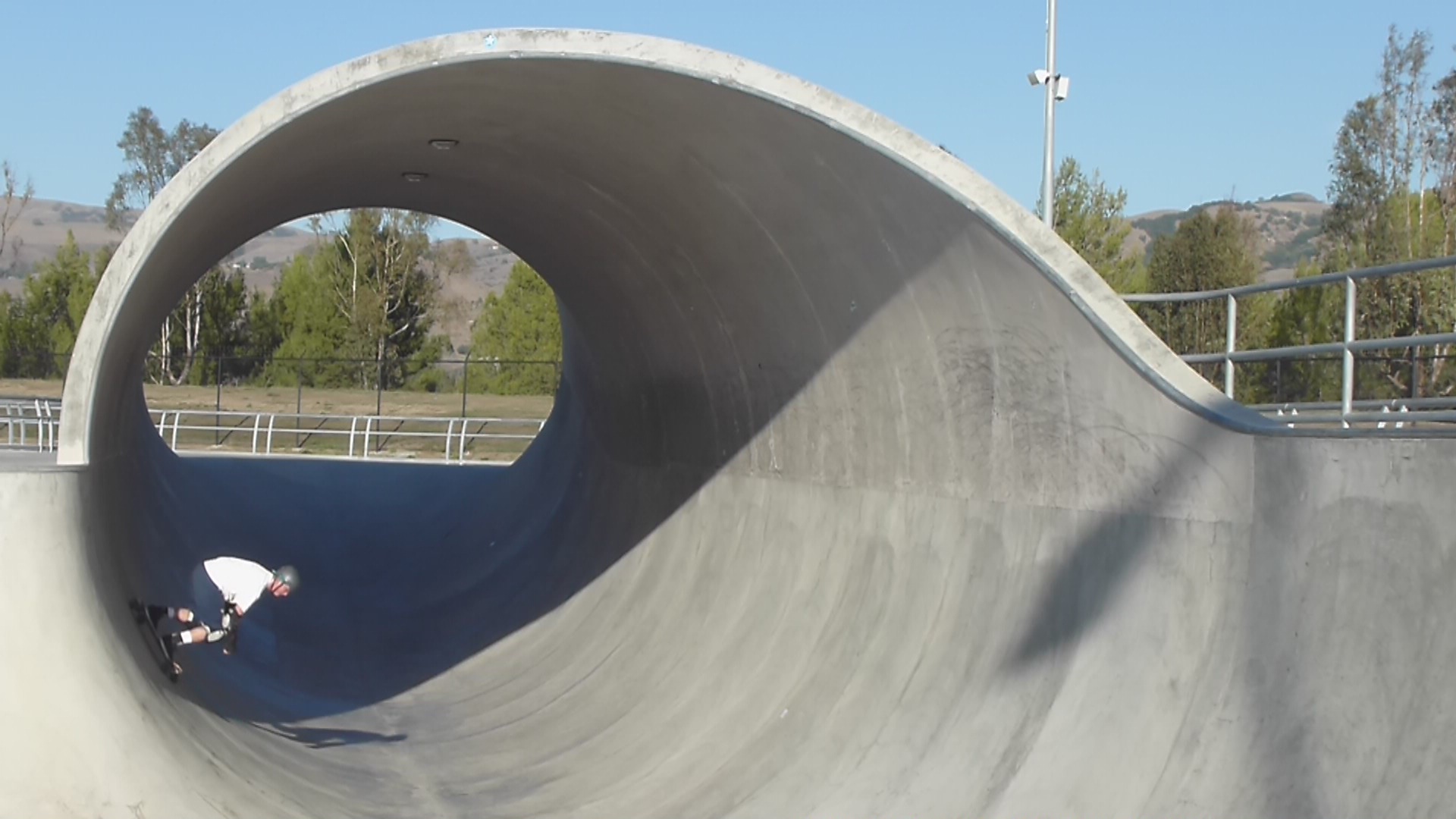 a man riding a skateboard on a ramp at a park