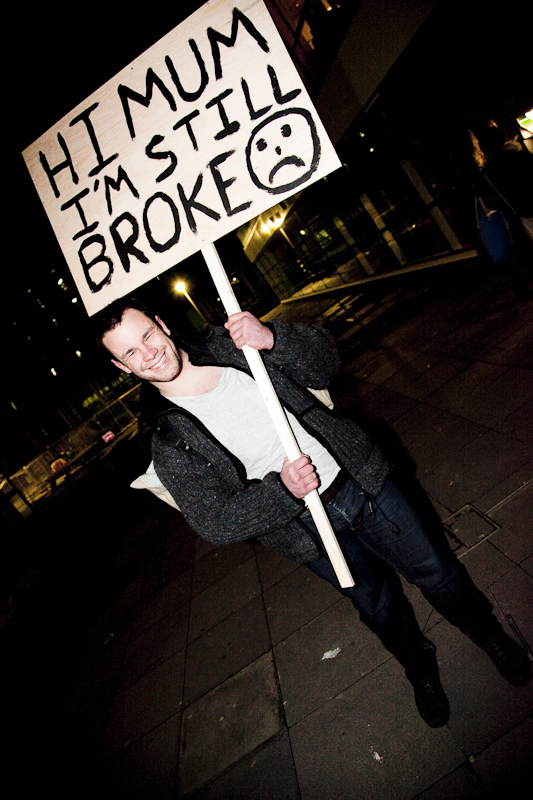 a man holding a sign with a smiley face on it