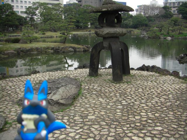 a couple of blue and black statues in a pond