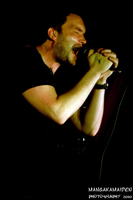 a man singing into a microphone with his mouth open
