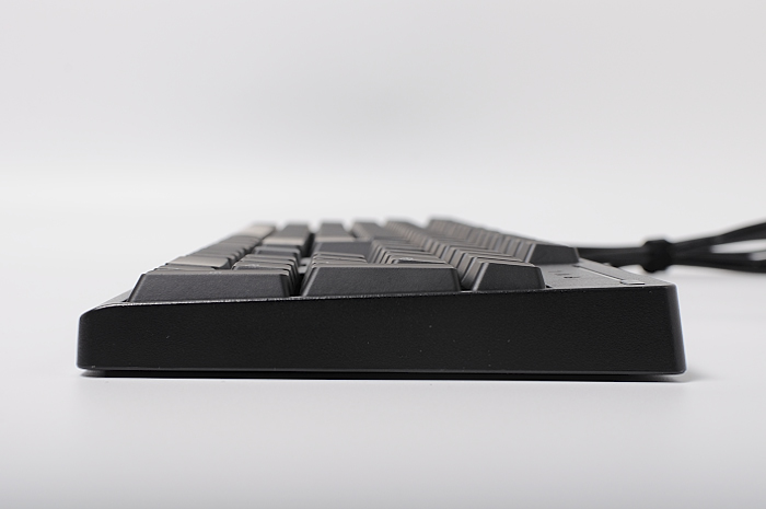 a long black and gray keyboard sits on a table