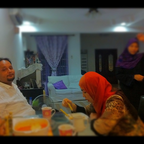 a man and woman in a living room having breakfast