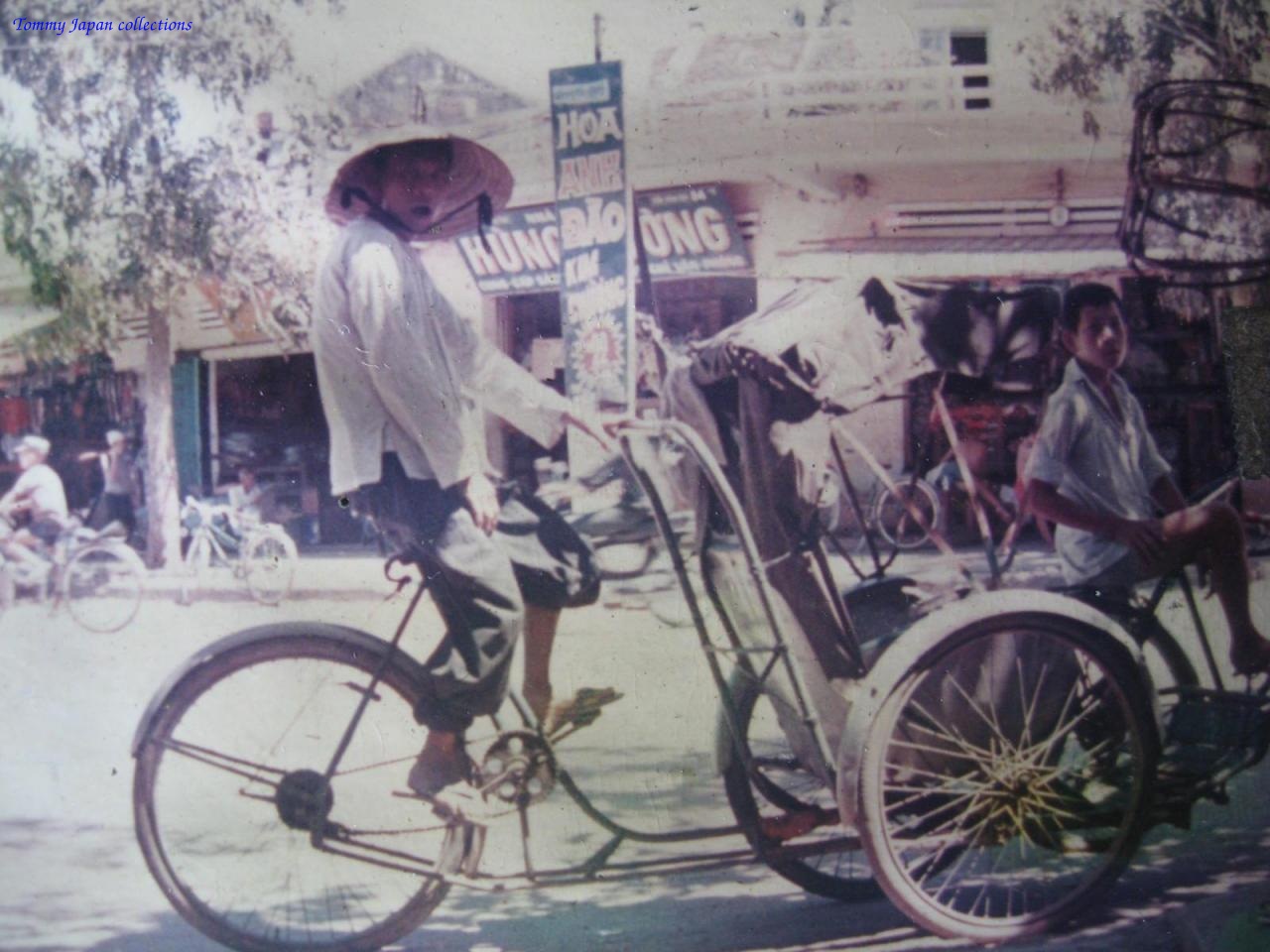 an old po of people standing around a bicycle with a basket
