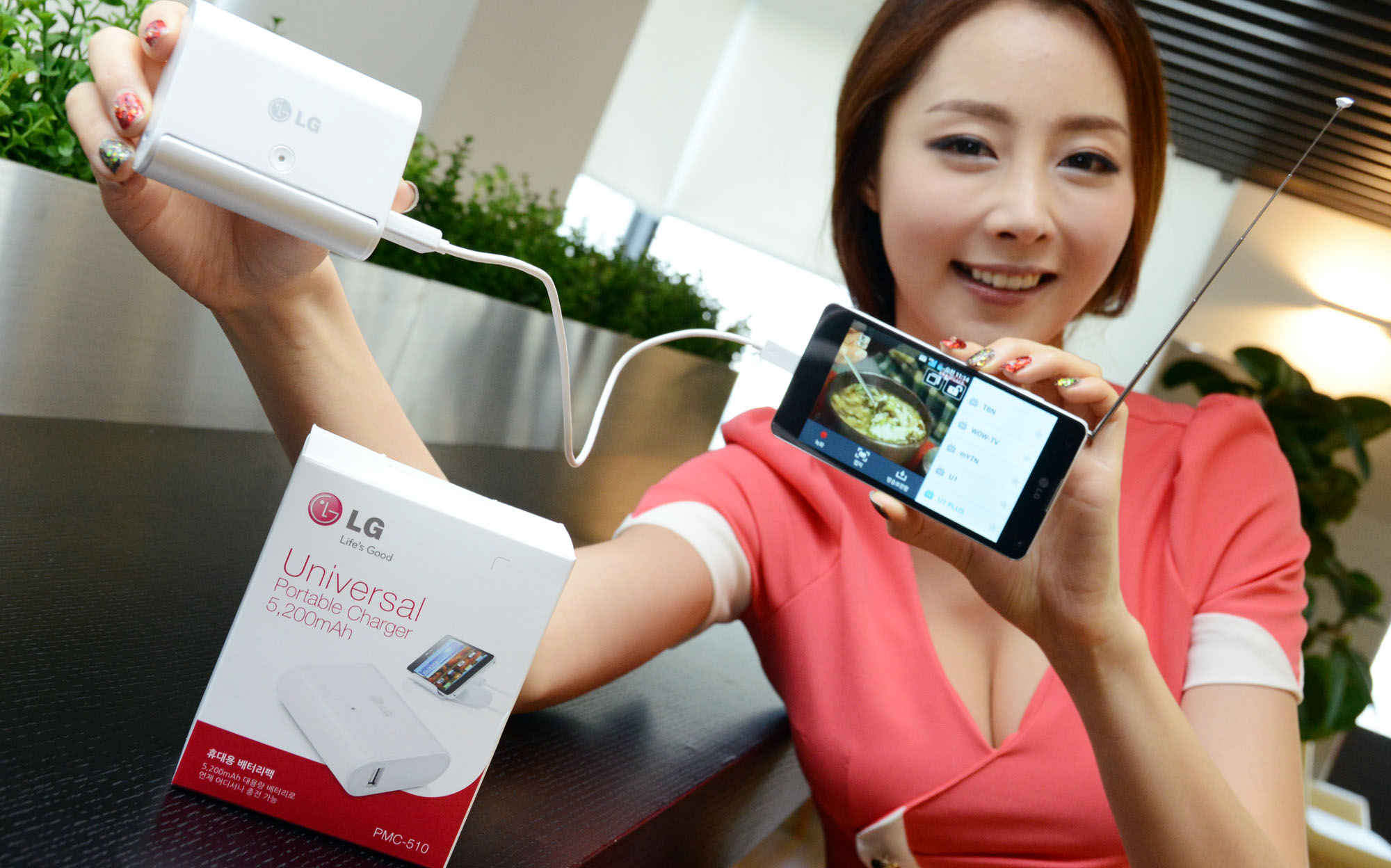 a woman holding up an electronic device that's charging